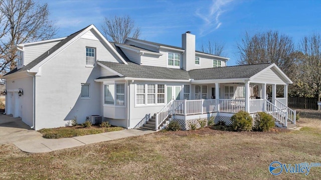 view of front of home with cooling unit, a front yard, and covered porch