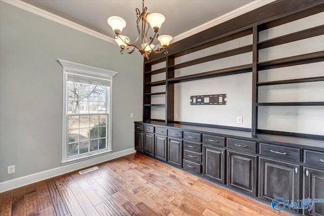 interior space with an inviting chandelier, crown molding, decorative light fixtures, and light wood-type flooring