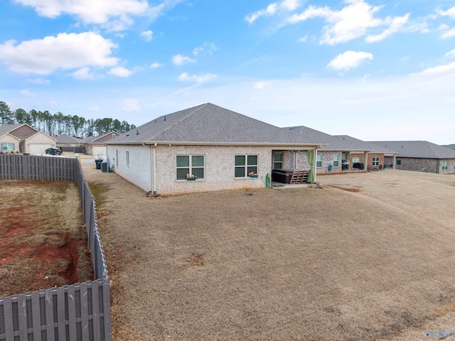 137 Sunlit Grove Dr, Harvest, AL 35749 - back of property featuring brick siding, a fenced backyard, and a shingled roof