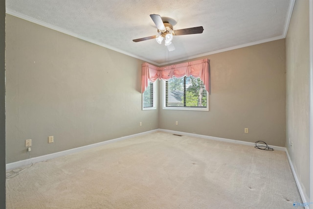 empty room featuring crown molding, light colored carpet, a ceiling fan, a textured ceiling, and baseboards