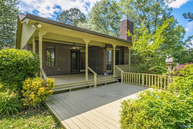 back of house featuring a deck, brick siding, ceiling fan, and a chimney