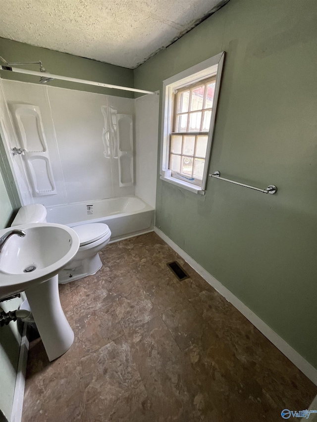 bathroom with washtub / shower combination and toilet