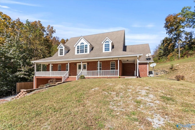 cape cod home with covered porch and a front yard