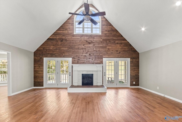 unfurnished living room with wood-type flooring, high vaulted ceiling, and plenty of natural light