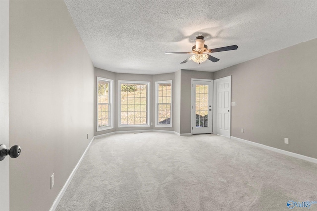 carpeted spare room with a textured ceiling and ceiling fan