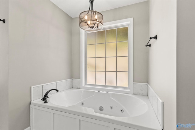 bathroom featuring a chandelier and a bathtub