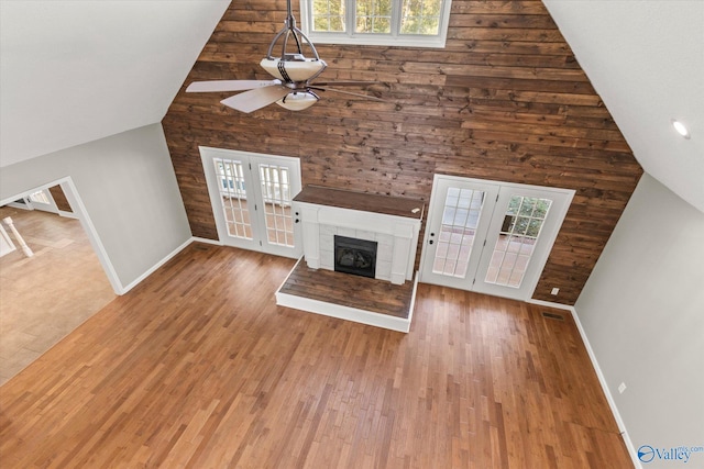 unfurnished living room featuring french doors, hardwood / wood-style flooring, ceiling fan, and vaulted ceiling