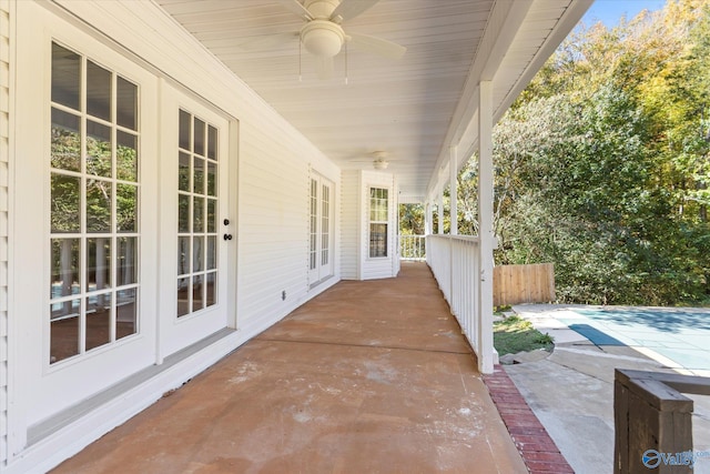 view of patio featuring french doors, a covered pool, and ceiling fan