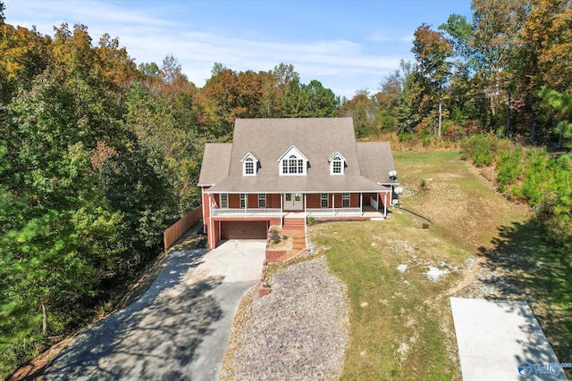 view of front of property with covered porch, a front yard, and a garage