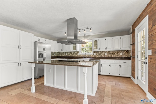 kitchen featuring appliances with stainless steel finishes, island range hood, a center island, and white cabinets