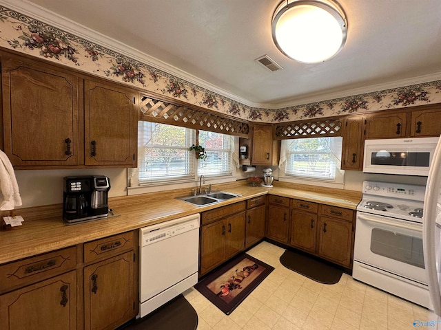 kitchen with sink, crown molding, and white appliances