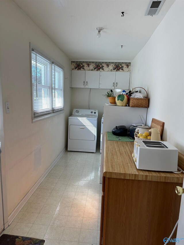 laundry room with washer and dryer and cabinets