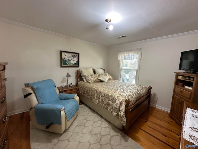 bedroom with light hardwood / wood-style floors and crown molding