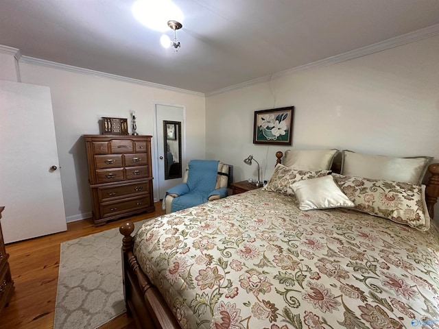 bedroom featuring ornamental molding and hardwood / wood-style flooring