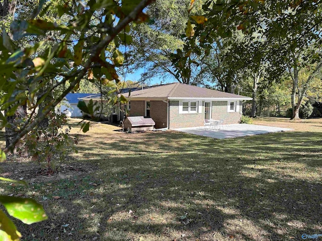 rear view of house featuring a yard and a patio area