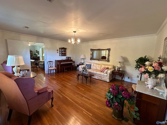 living room featuring crown molding, hardwood / wood-style flooring, and an inviting chandelier