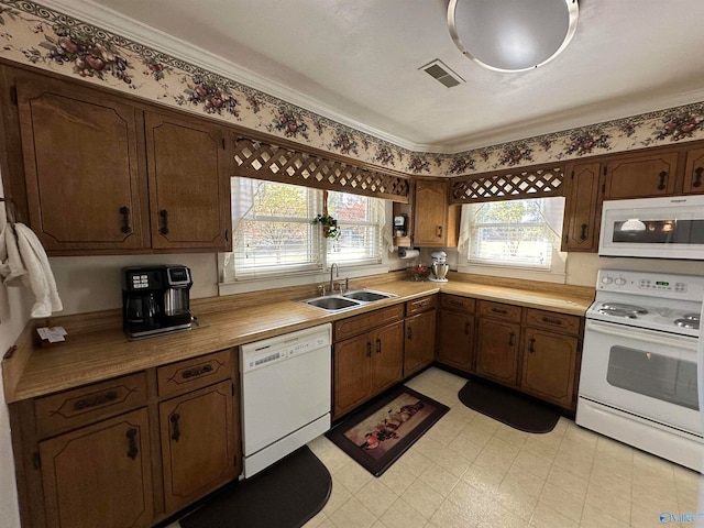 kitchen featuring sink, crown molding, and white appliances