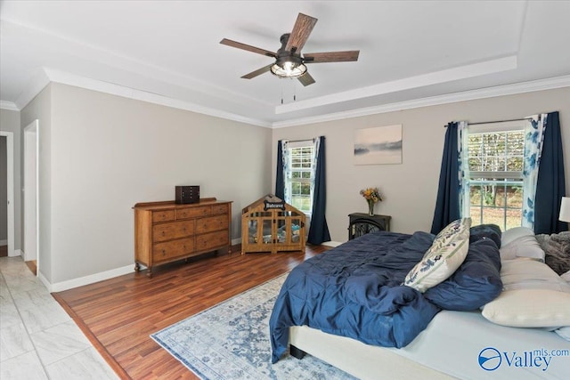 bedroom with ceiling fan, multiple windows, and wood-type flooring