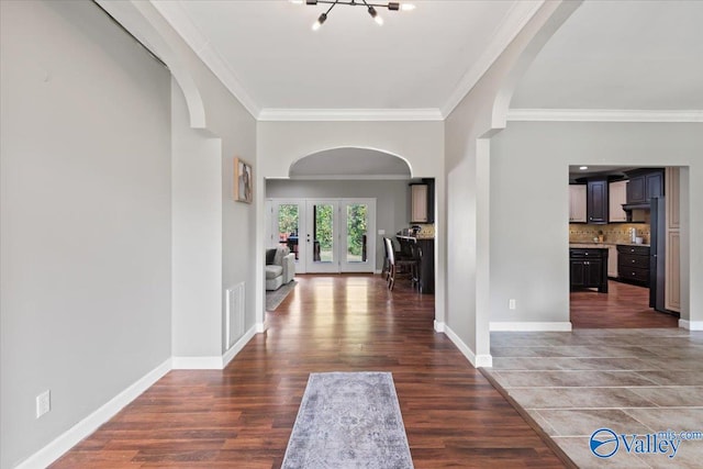 entrance foyer featuring ornamental molding, french doors, and dark hardwood / wood-style flooring