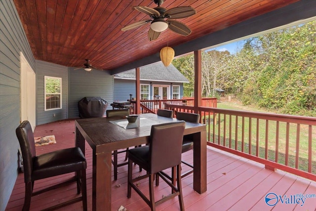 wooden terrace with a grill, a lawn, and ceiling fan