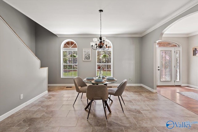 dining space featuring ornamental molding and an inviting chandelier