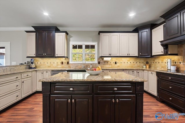 kitchen with white cabinetry, hardwood / wood-style floors, decorative backsplash, and crown molding