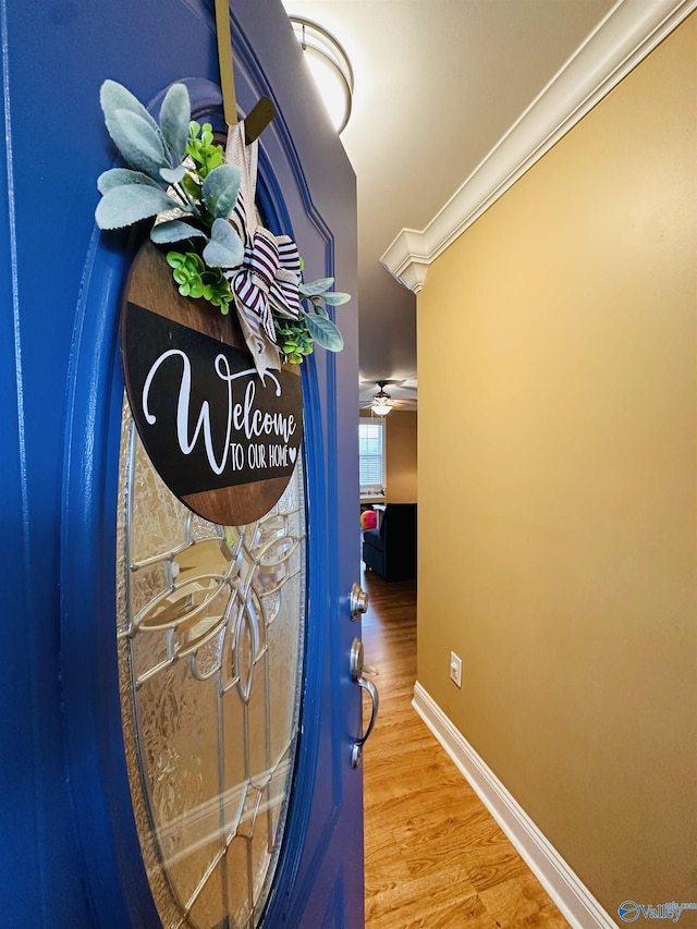 hallway with wood-type flooring and crown molding