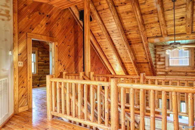 interior space with light hardwood / wood-style flooring, lofted ceiling with beams, log walls, and wood ceiling