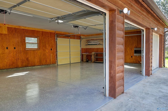 garage with a garage door opener and wooden walls