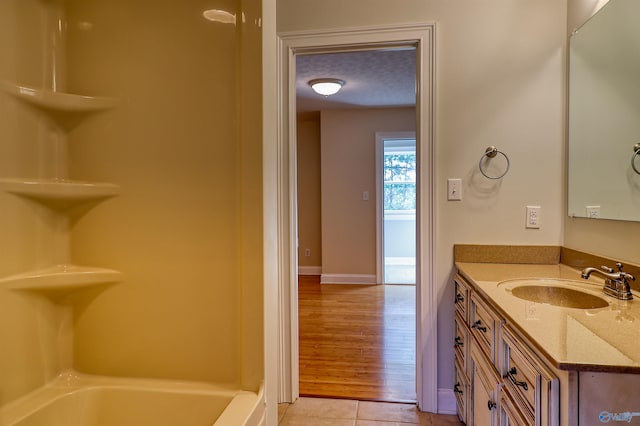 bathroom featuring vanity, a textured ceiling, hardwood / wood-style flooring, and a bathing tub