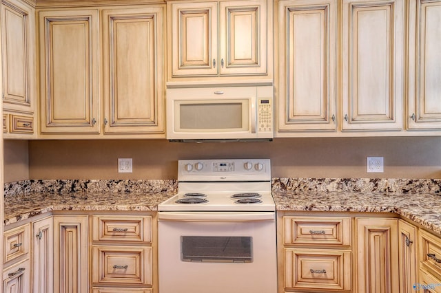 kitchen with white appliances and light stone countertops