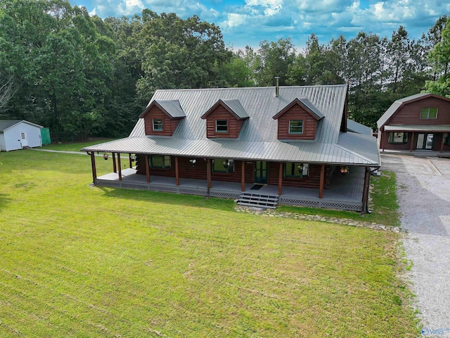 view of front of house with a porch, an outbuilding, and a front yard