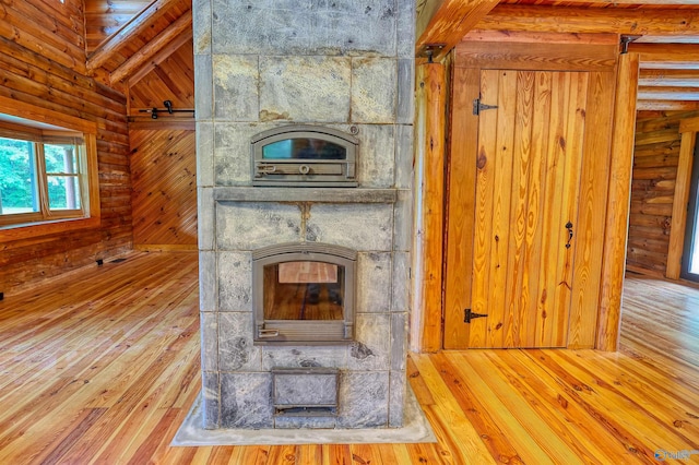 details with wood walls, wood-type flooring, and a wood stove