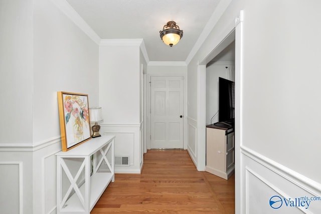 hall featuring crown molding and light hardwood / wood-style floors