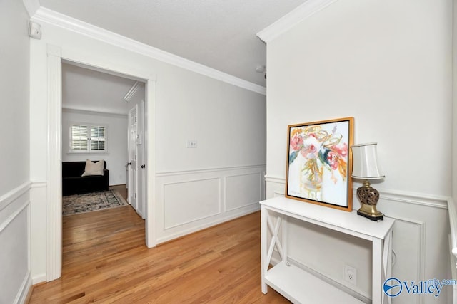 hallway with crown molding and light hardwood / wood-style flooring