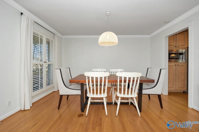 dining space featuring crown molding and light hardwood / wood-style flooring