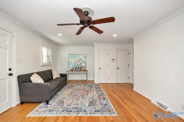 living room with wood-type flooring, a textured ceiling, and crown molding