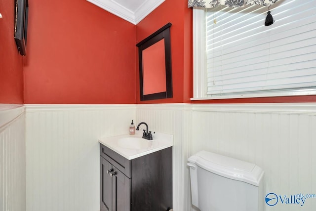 bathroom with vanity, crown molding, and toilet