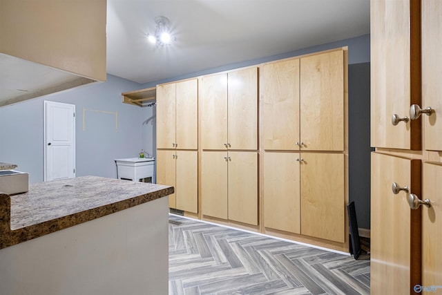 interior space with dark parquet floors and light brown cabinets