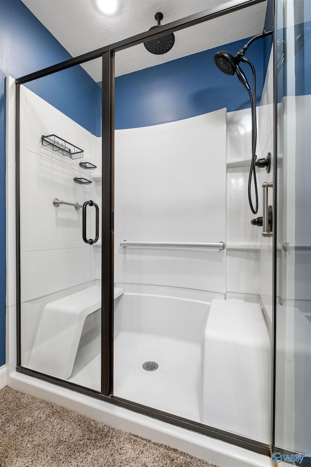 bathroom with a shower with door and a textured ceiling