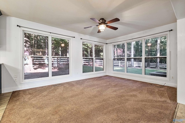 unfurnished sunroom with ceiling fan and plenty of natural light