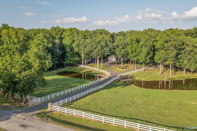 view of home's community featuring a yard, a water view, and a rural view