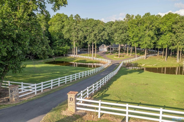 view of property's community with a lawn, a water view, and a rural view