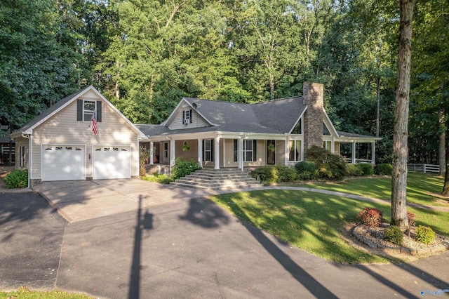 view of front facade with covered porch, a garage, and a front yard