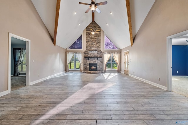 unfurnished living room featuring beamed ceiling, ceiling fan, and high vaulted ceiling