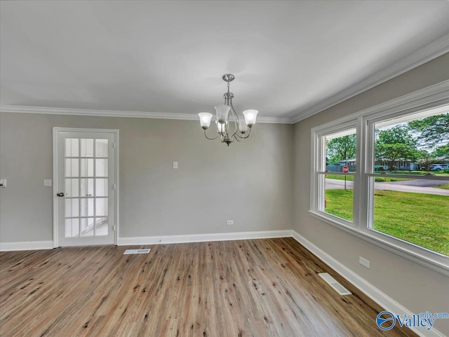 1419 11th St SE, Cullman, AL 35055 - empty room featuring crown molding, an inviting chandelier, baseboards, wood finished floors, and visible vents