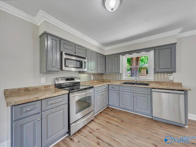 1419 11th St SE, Cullman, AL 35055 - kitchen featuring crown molding, a sink, light wood finished floors, stainless steel appliances, and gray cabinetry