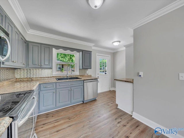 1419 11th St SE, Cullman, AL 35055 - kitchen featuring crown molding, appliances with stainless steel finishes, tasteful backsplash, a sink, and light wood-style floors