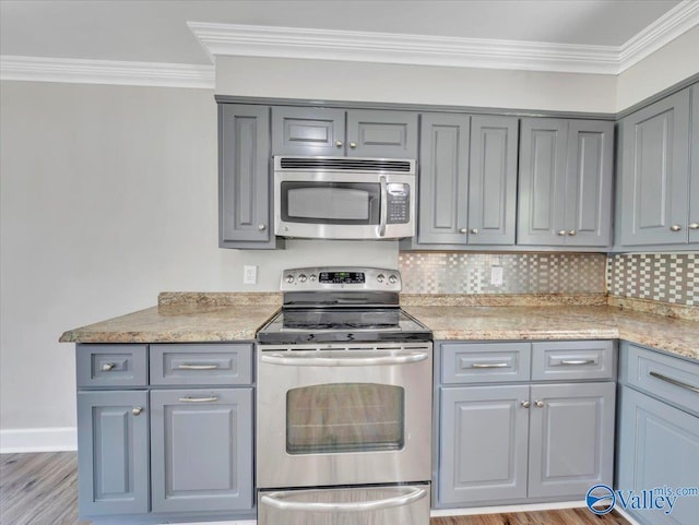 1419 11th St SE, Cullman, AL 35055 - kitchen with gray cabinets, appliances with stainless steel finishes, tasteful backsplash, light wood finished floors, and ornamental molding