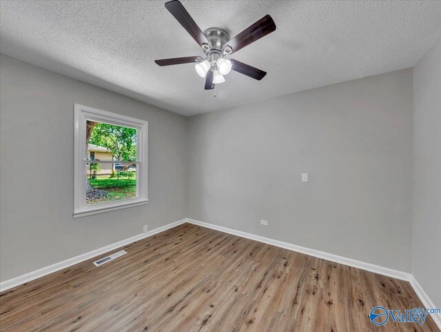 1419 11th St SE, Cullman, AL 35055 - unfurnished room featuring a textured ceiling, baseboards, wood finished floors, and visible vents